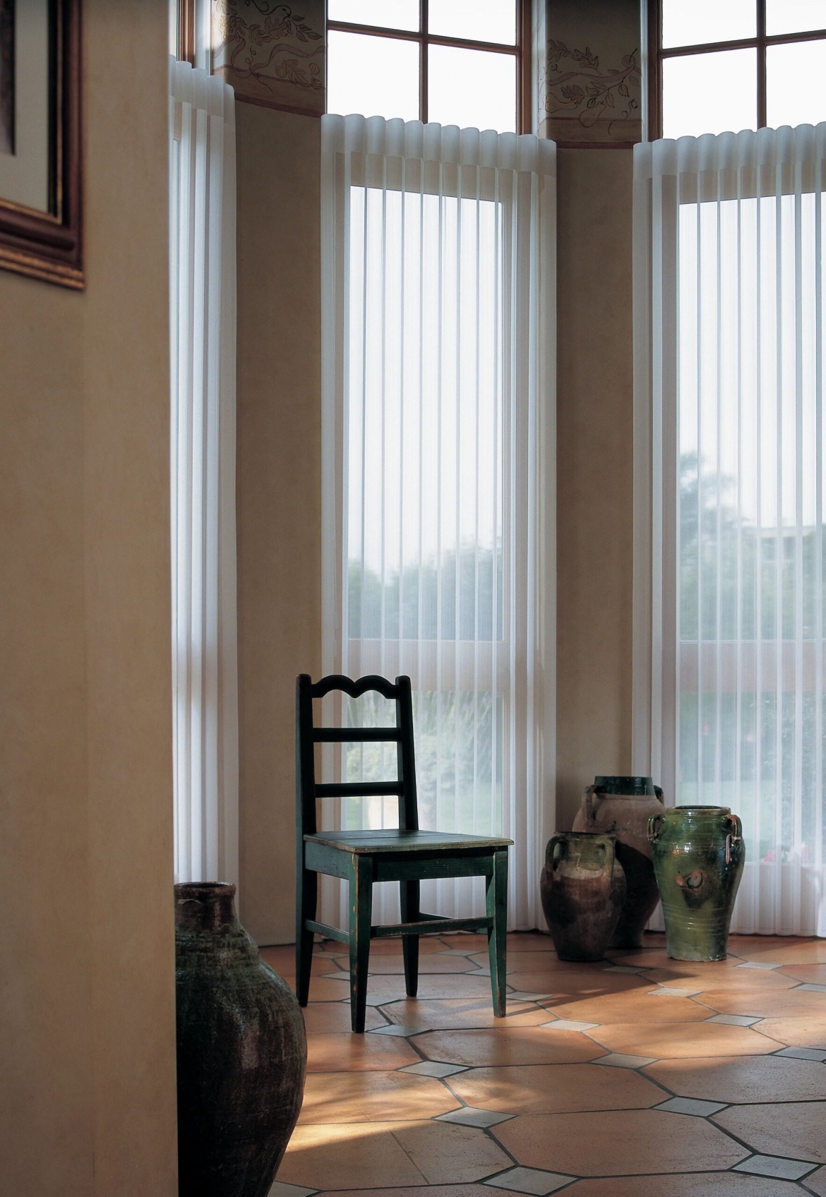 A wooden chair in a tile floor foyer with shed shades over the windows