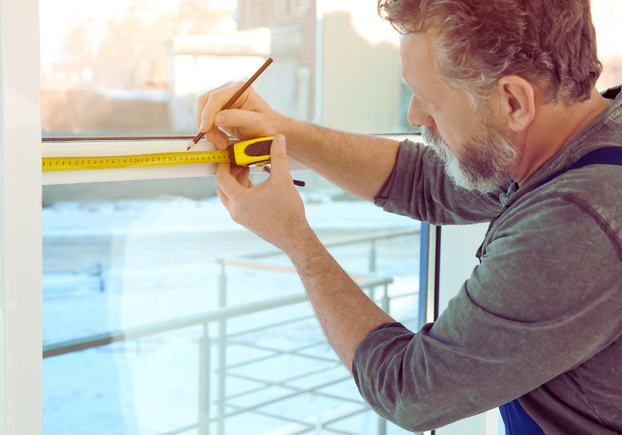 A person measuring a window